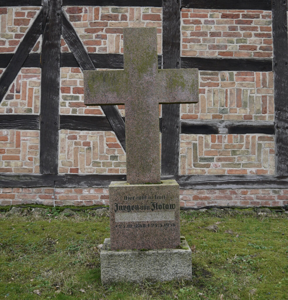 Stuer, Friedhof, Grabkreuz für Jürgen von Flotow von 1965 mit ausgemeißelter Passage